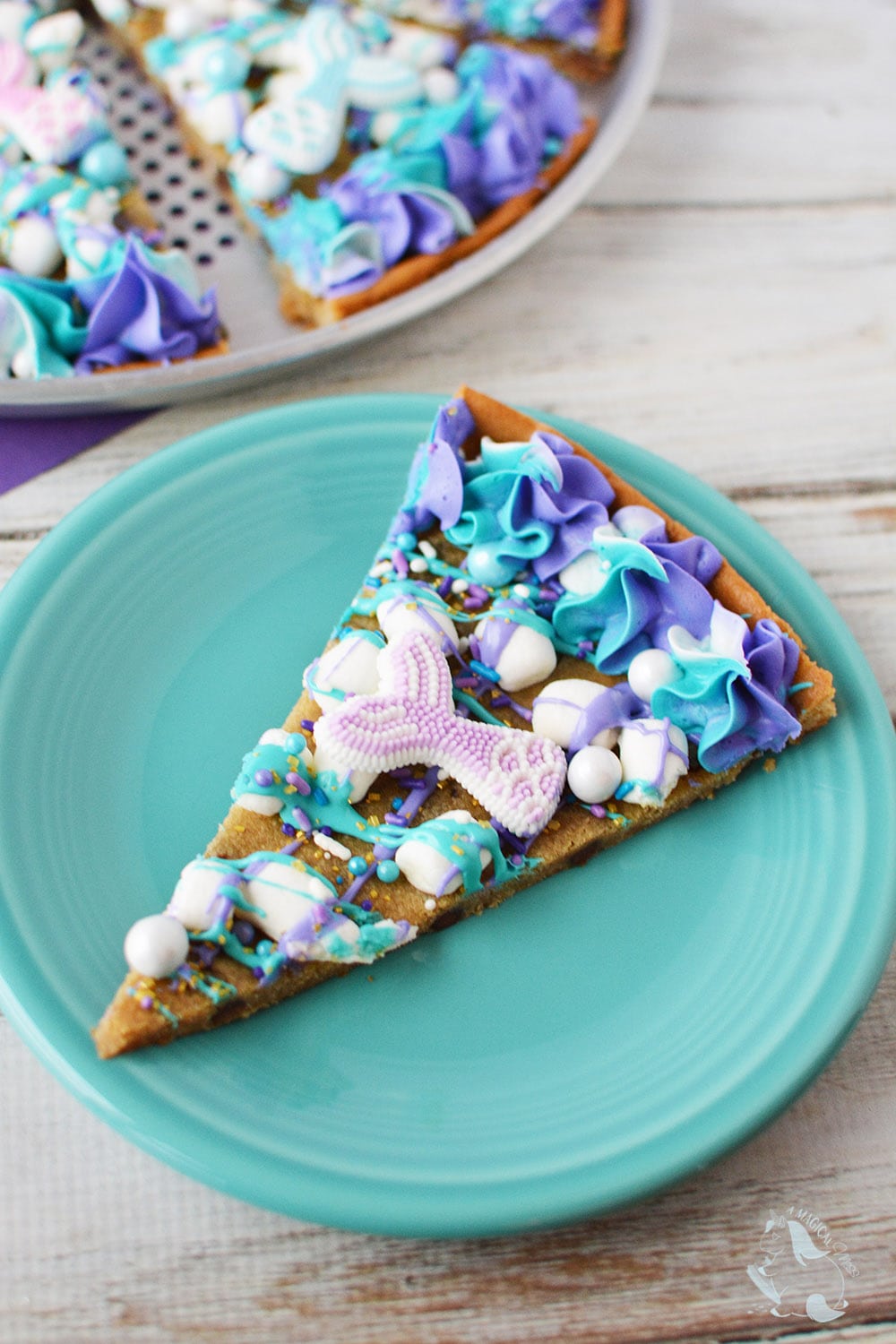 Mermaid dessert pizza sliced on a blue plate. 