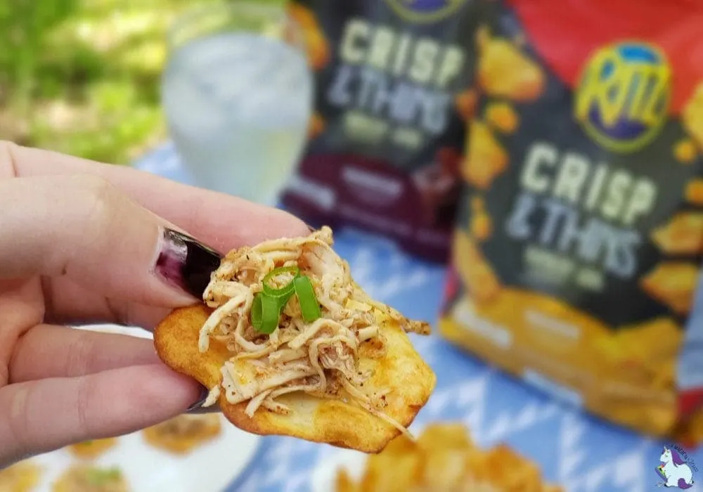 Holding a Ritz Crisp topped with shredded chicken. 