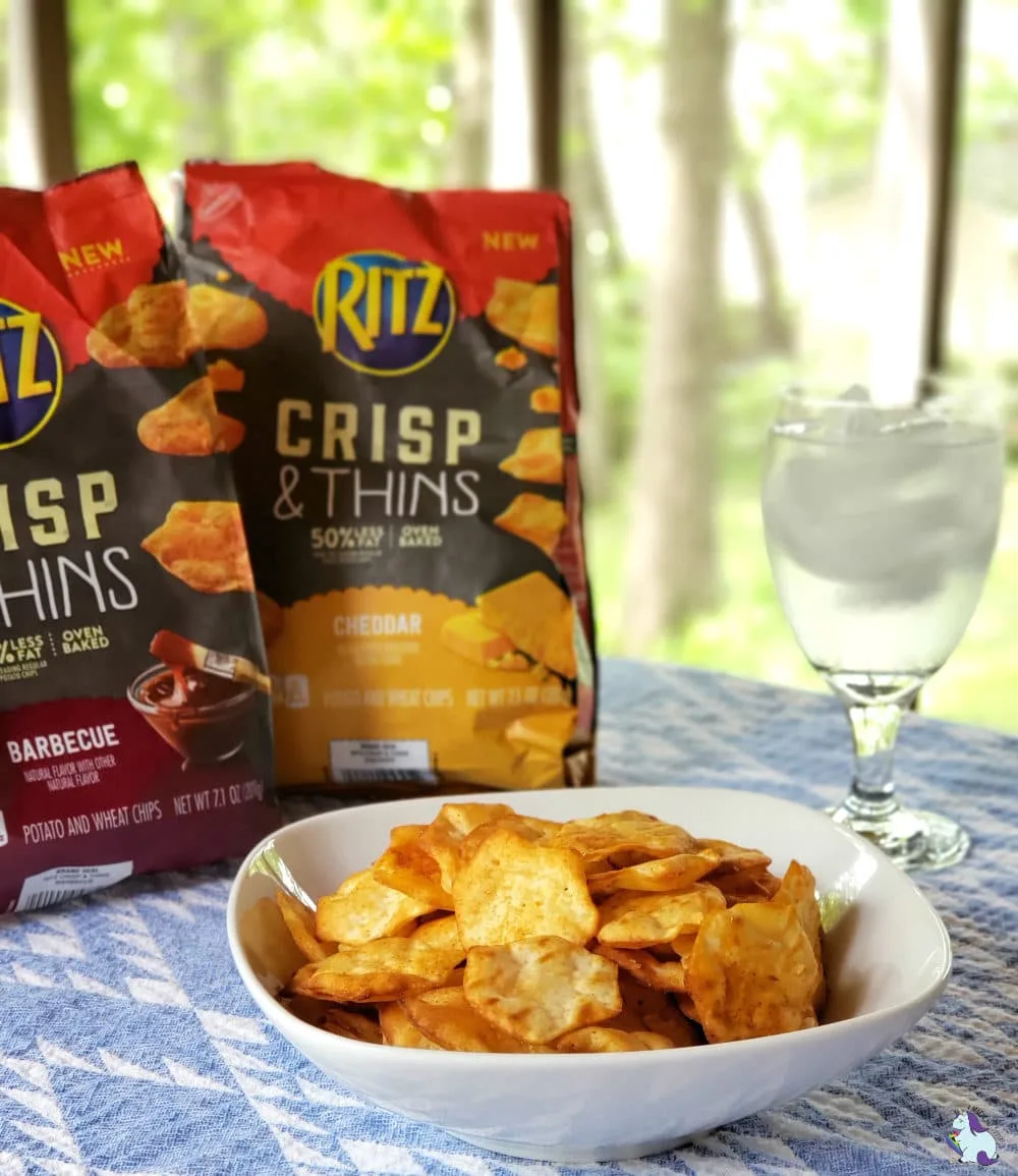 RITZ Crisp & Thins 2 New Flavors on a table with a glass of water. 