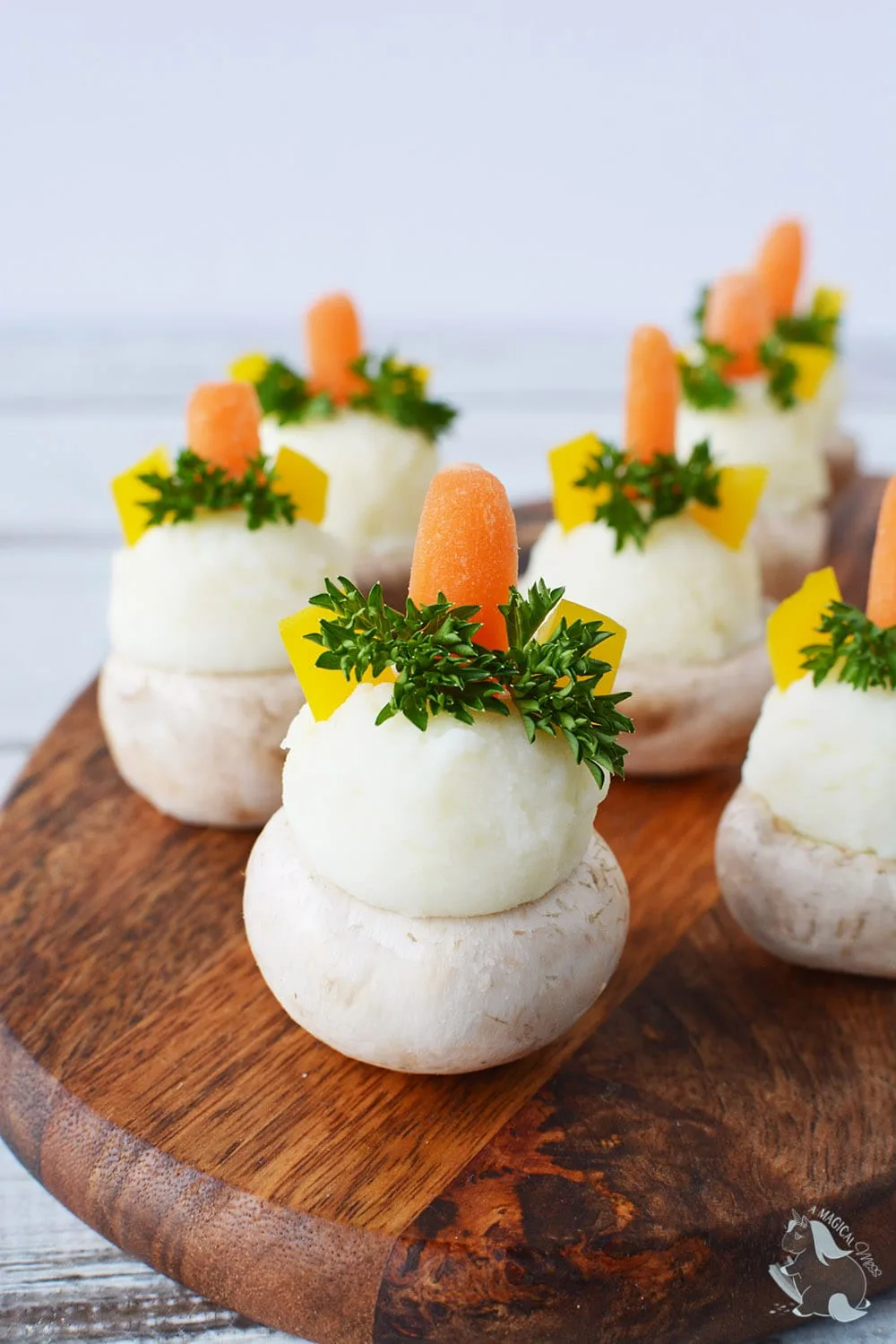 Stuffed mushrooms sitting on a serving board. 