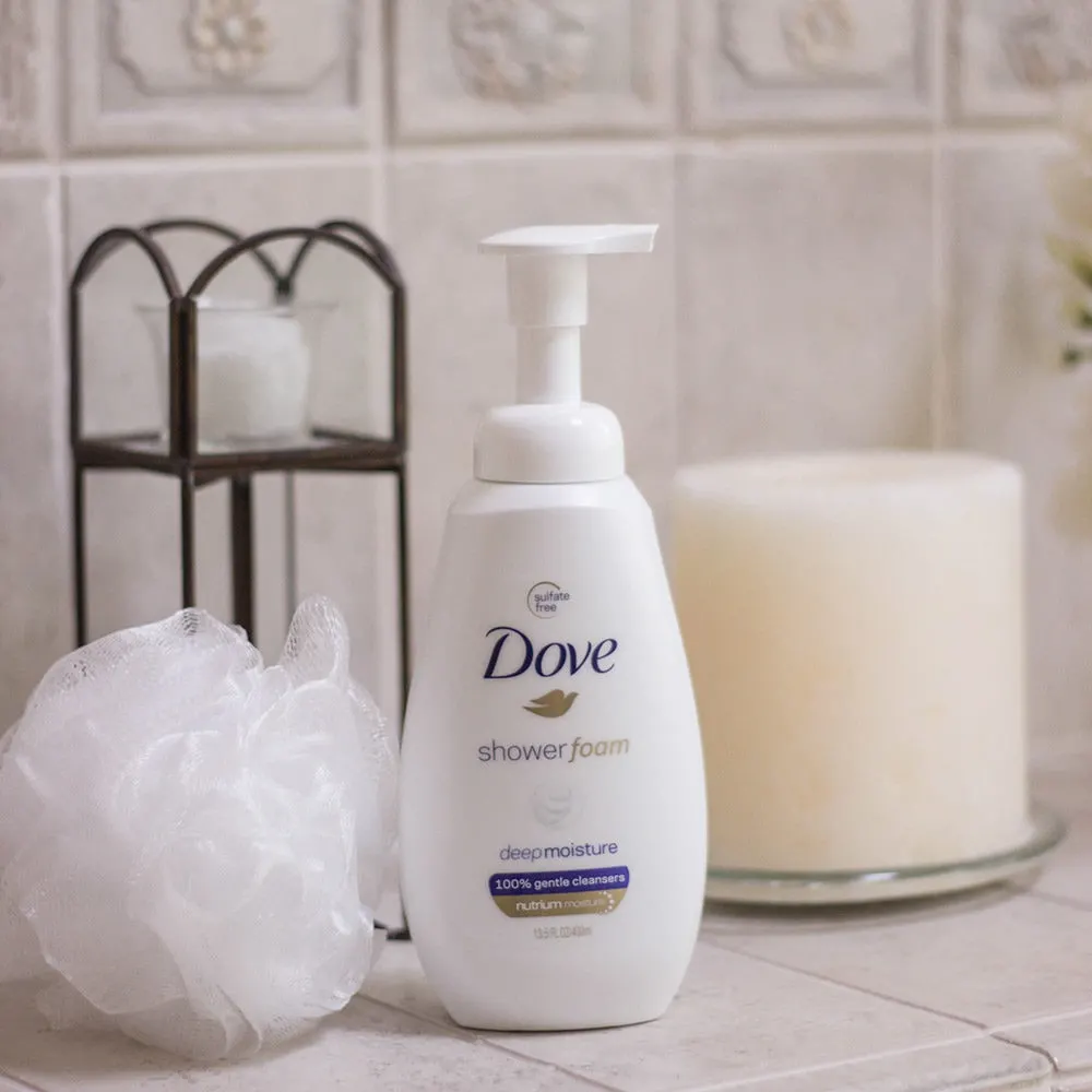 Ledge of bath tub with candles and dove shower foam. 