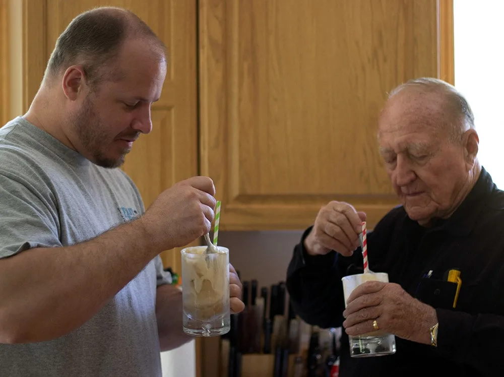 Mike and Papa drinking floats with spoons and straws. 