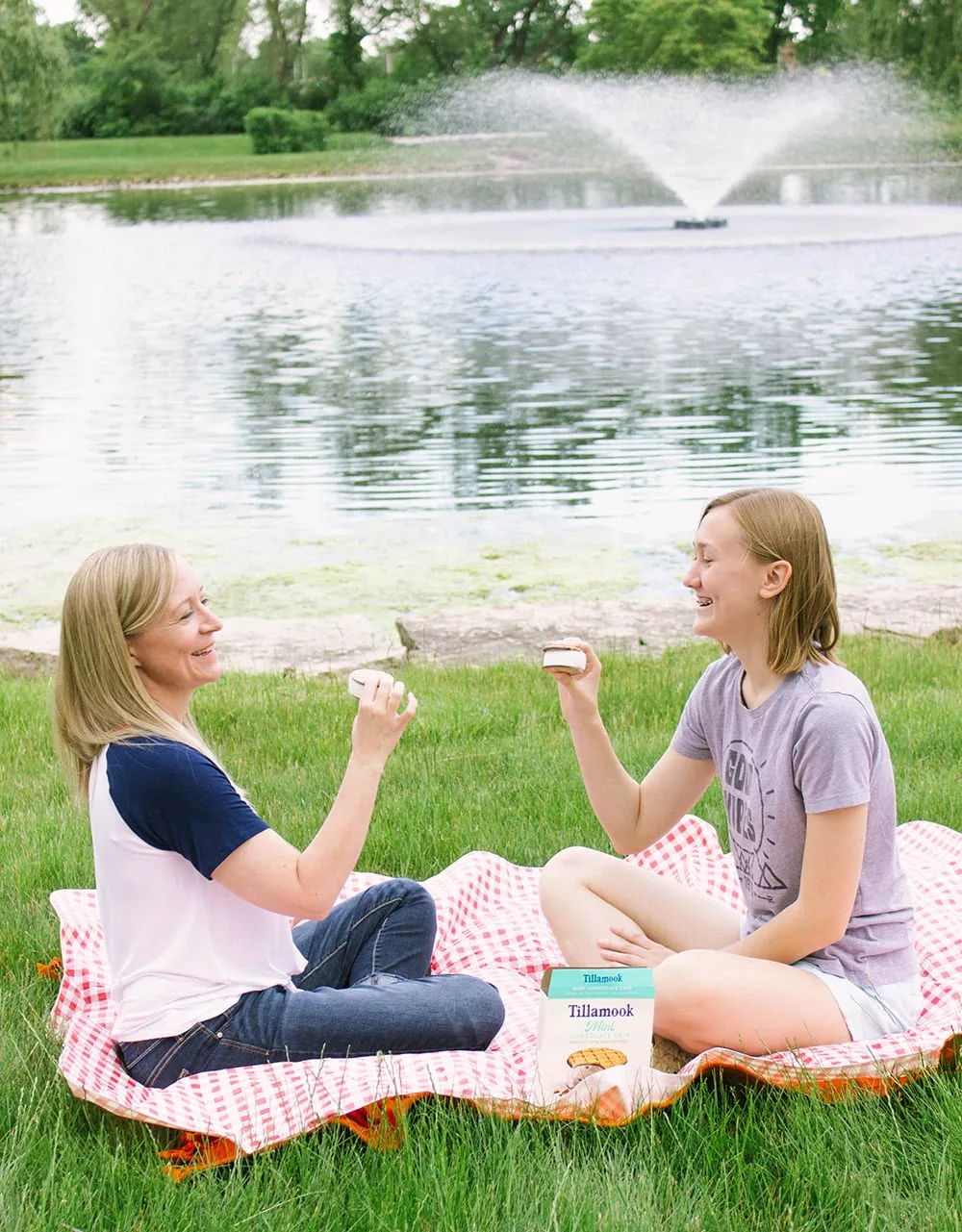 Jennie and Chesney on a picnic blanket in front of water. 