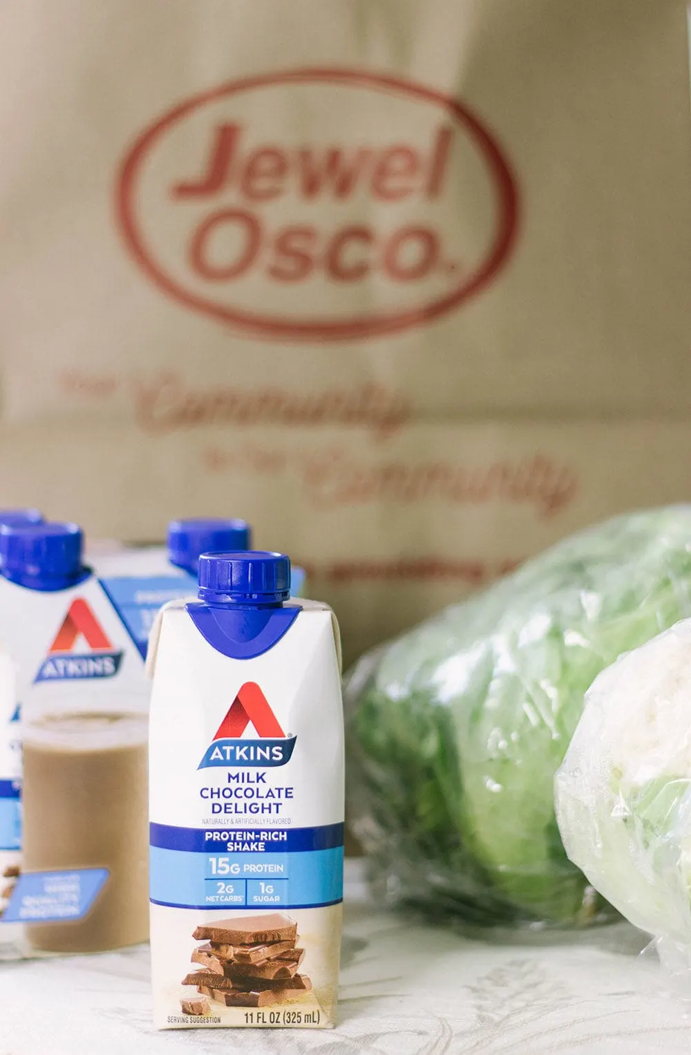 Atkins shakes in front of Jewel-Osco bag.