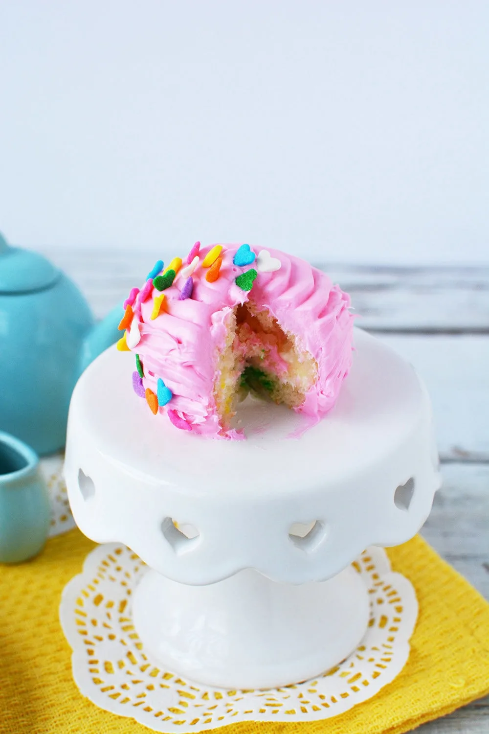 Pink mini cake with a slice cut from it.