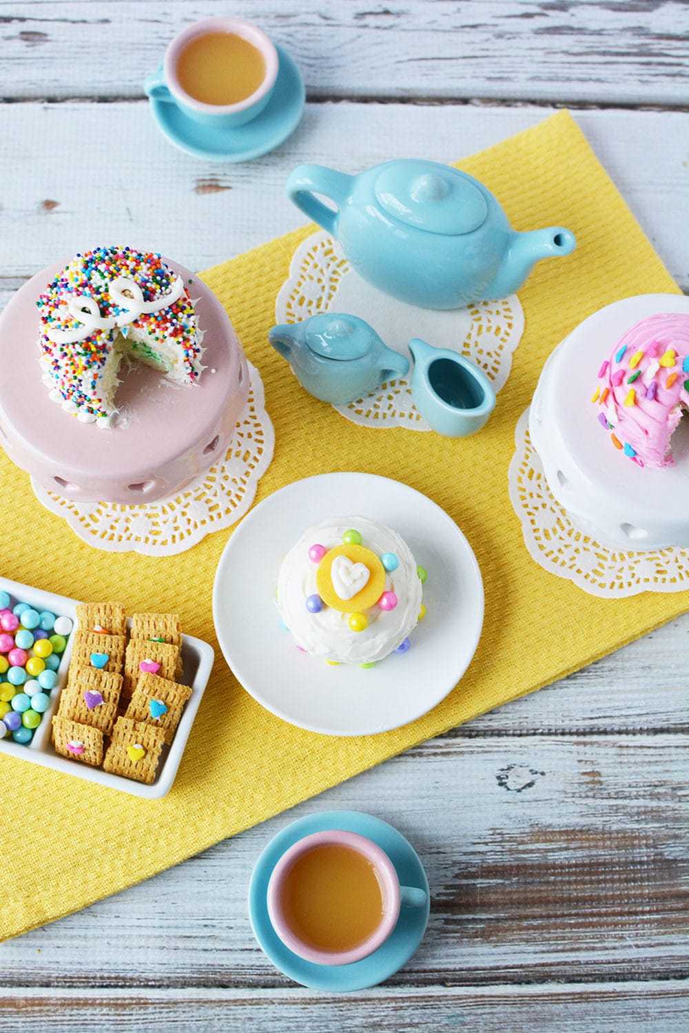 Overhead shot of a tea party with mini cakes