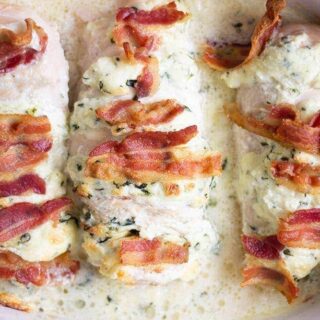 Bacon and spinach Hasselback chicken in a casserole dish.