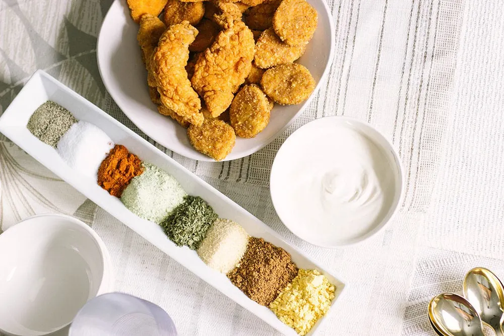 Bowl of chicken strips, base dip, and a bunch of spices.