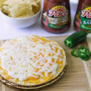 Double decker taco pizza with pace sauce in the background.