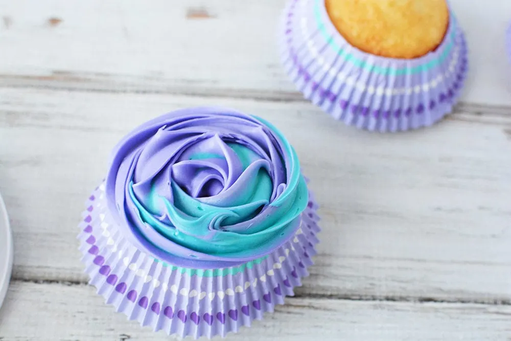 Blue and purple swirled frosting on a cupcake.