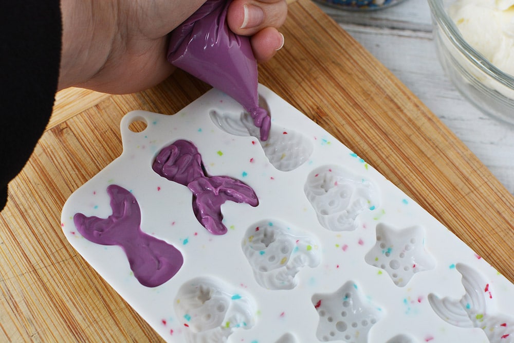 Pouring candy melts into mermaid fin mold. 