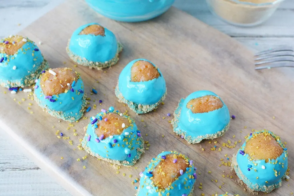 Donuts dipped in blue icing on a board. 