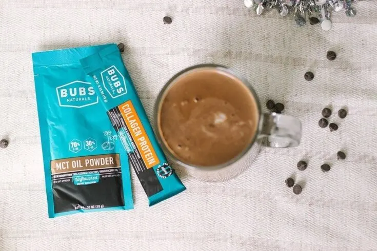 Packets of BUBS next to a mug of keto hot chocolate