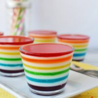 Cups of rainbow Jell-o layers on a table