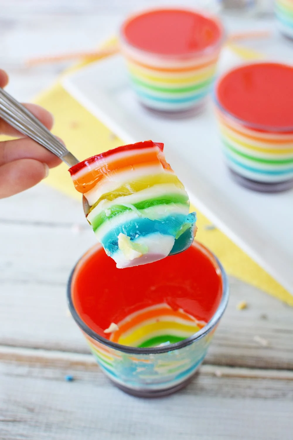 Spoonful of rainbow layered Jell-o that shows all the colors. 