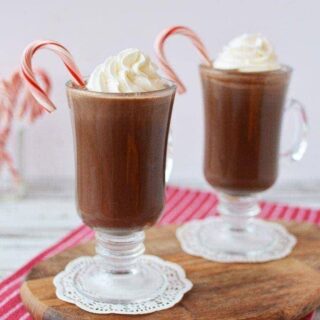 Mugs filled with coffee drink with whipped cream and candy canes