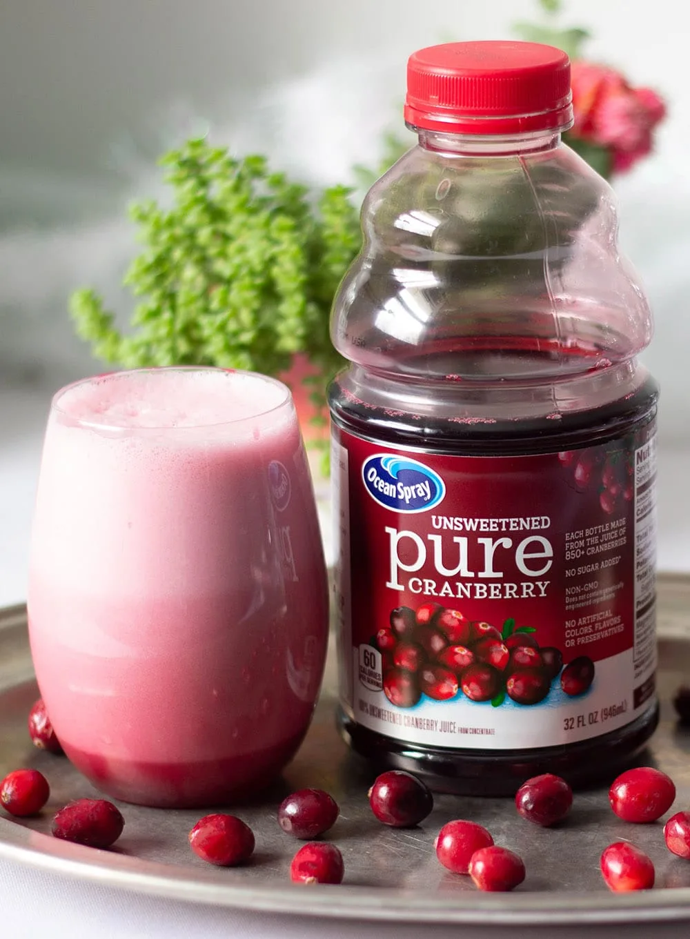 Cranberry slushy drink next to bottle.