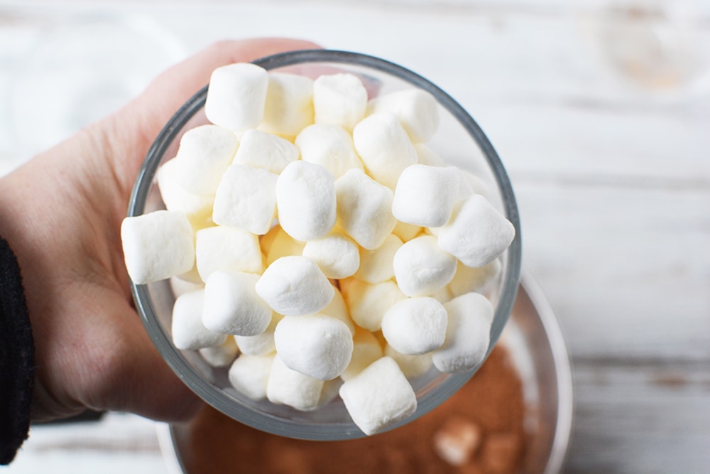 Holding a bowl of marshmallows. 