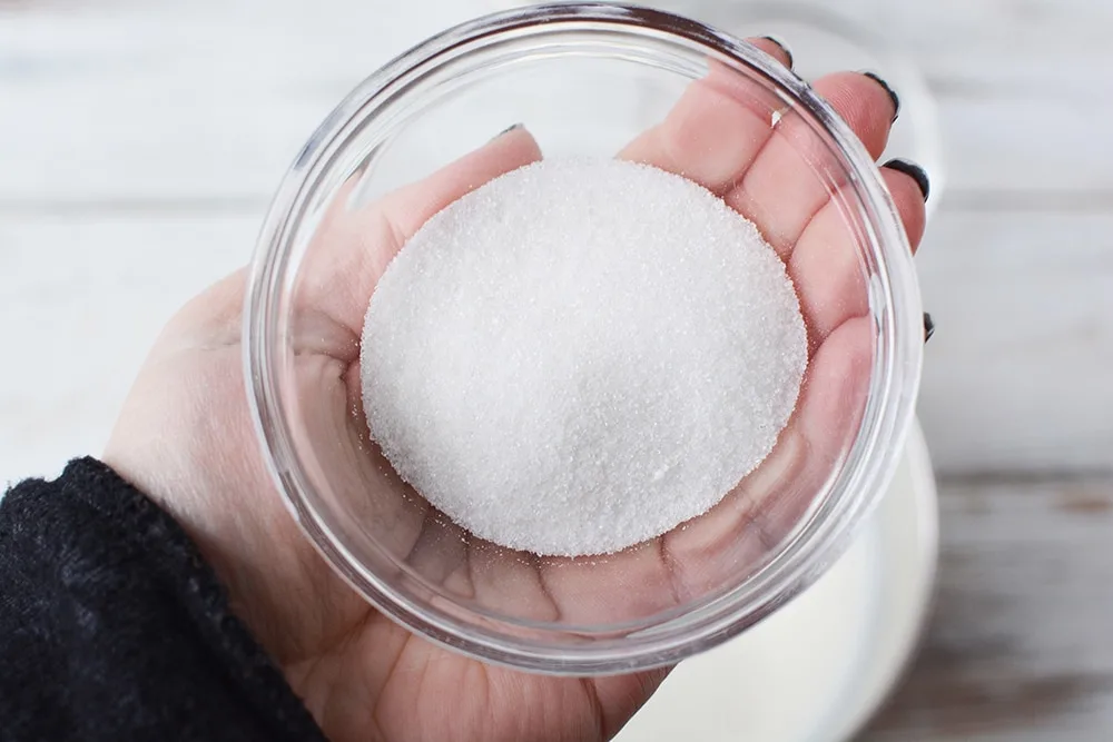 Holding a bowl with sugar in it. 