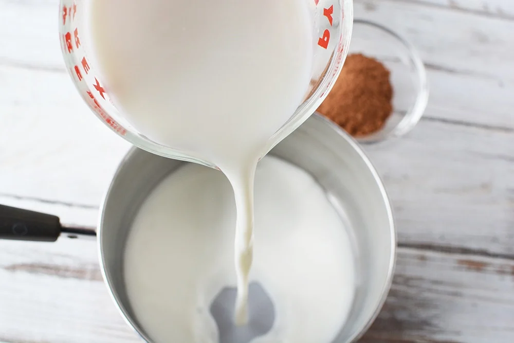 Pouring milk into a saucepan.