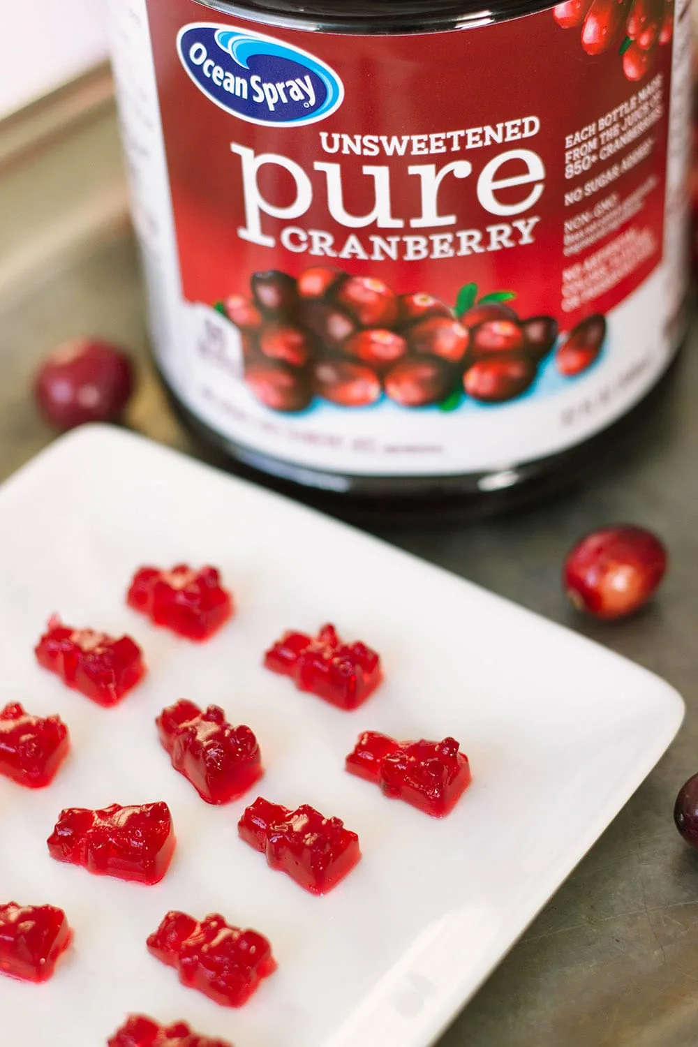 Cranberry gummies next to juice bottle.