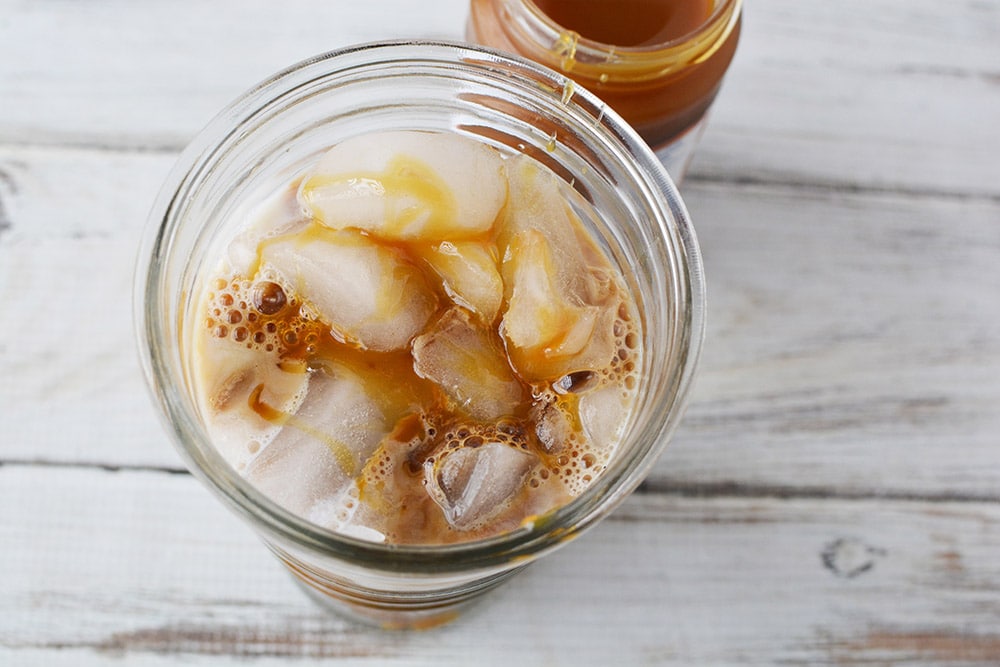 Caramel iced coffee in glass tumbler.