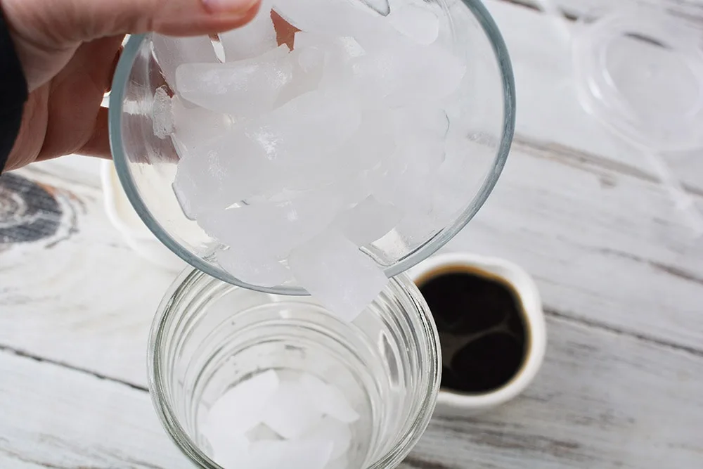 Adding ice to tumbler.