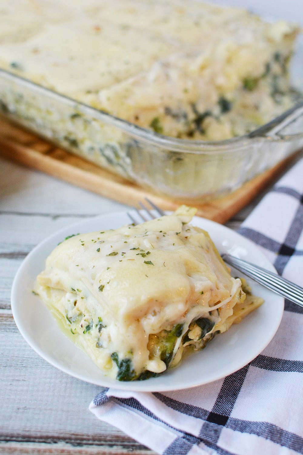Chicken lasagna with spinach topped with cheese.