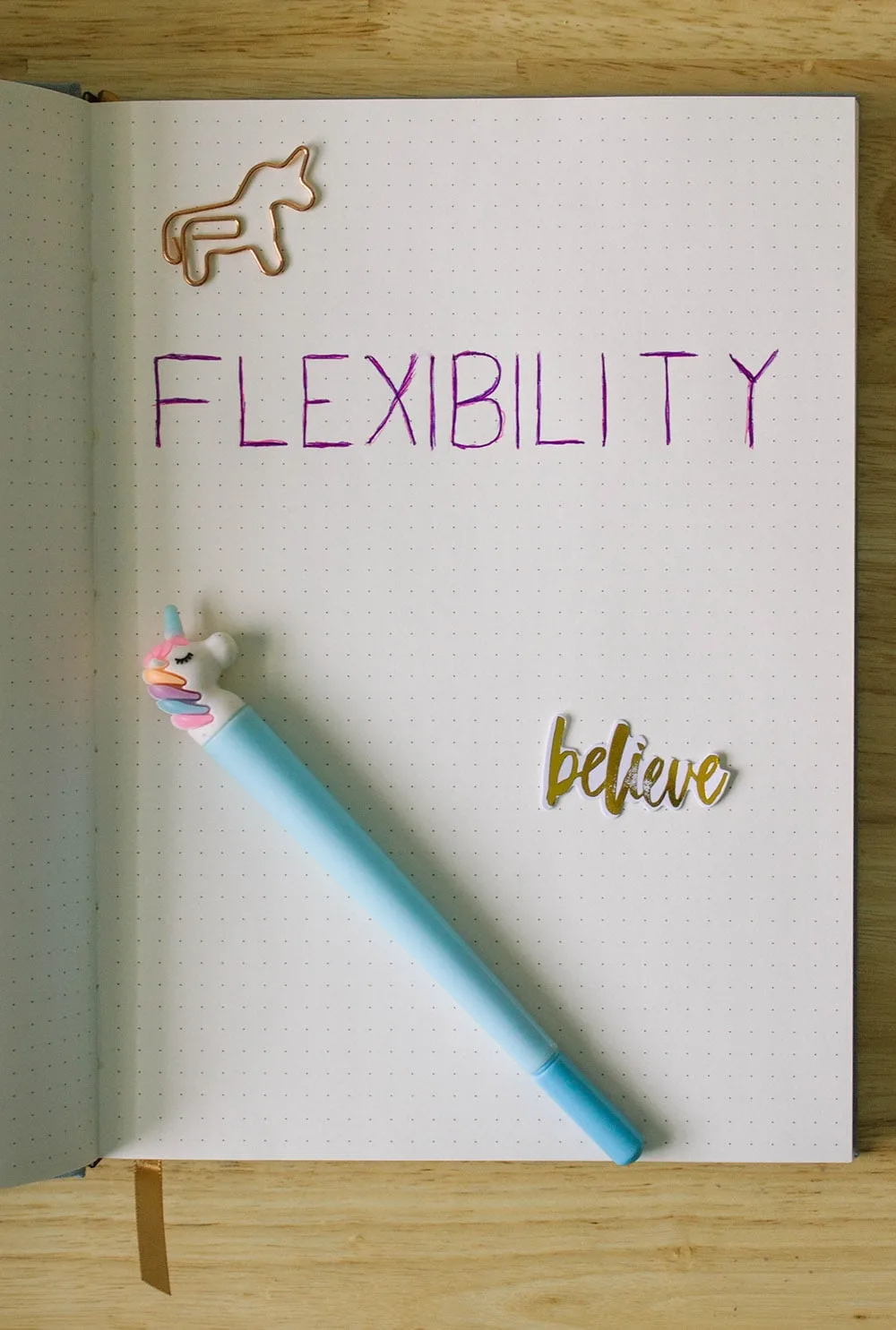 The word FLEXIBILITY written in a dot journal with a sticker and a unicorn pen. 