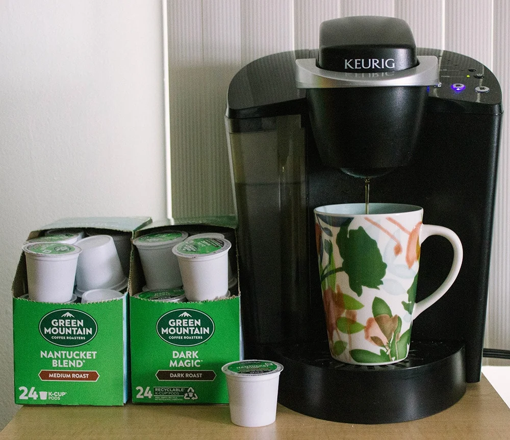 Green Mountain K-cups next to a Keurig. 