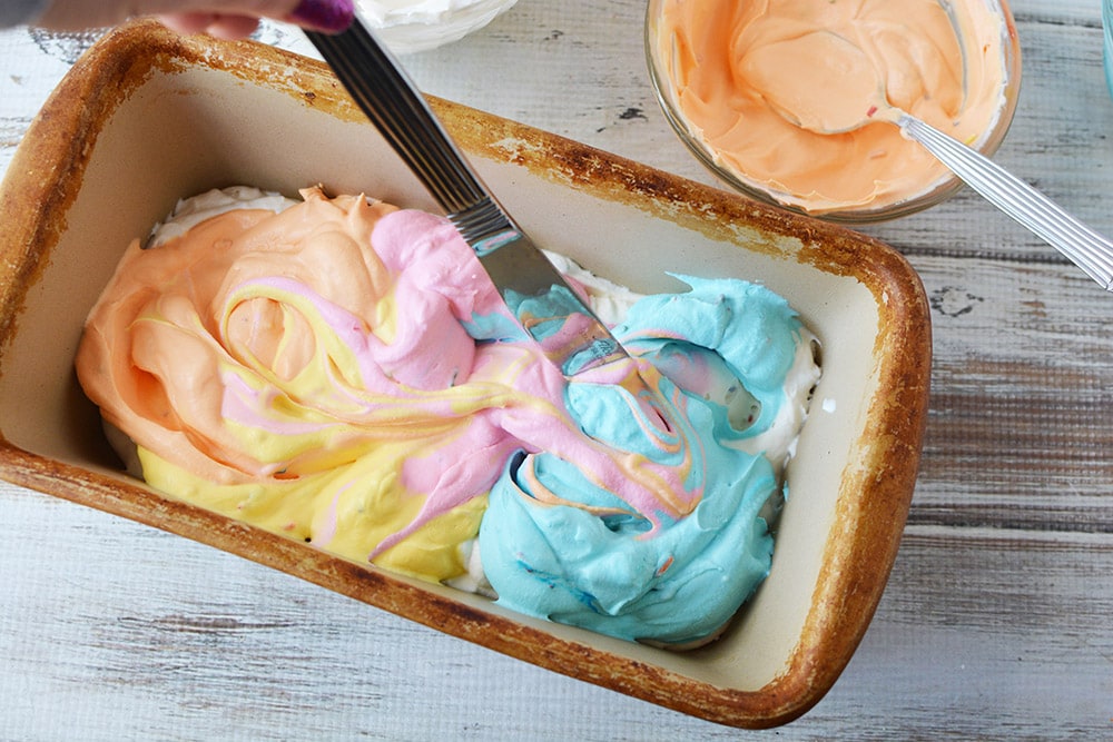 Swirling colored ice cream with a knife.