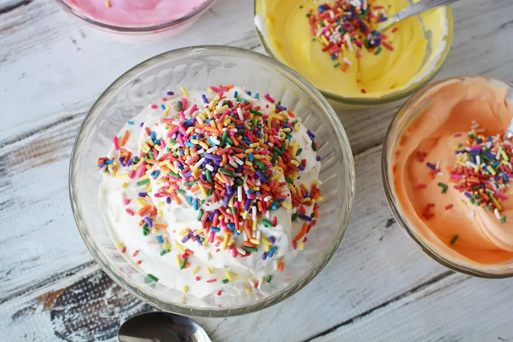 Sprinkles on top of colored ice cream.