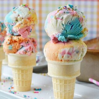 Three ice cream cones with scoops of unicorn ice cream