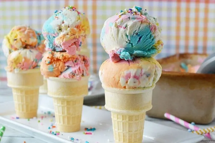 Three ice cream cones with scoops of unicorn ice cream