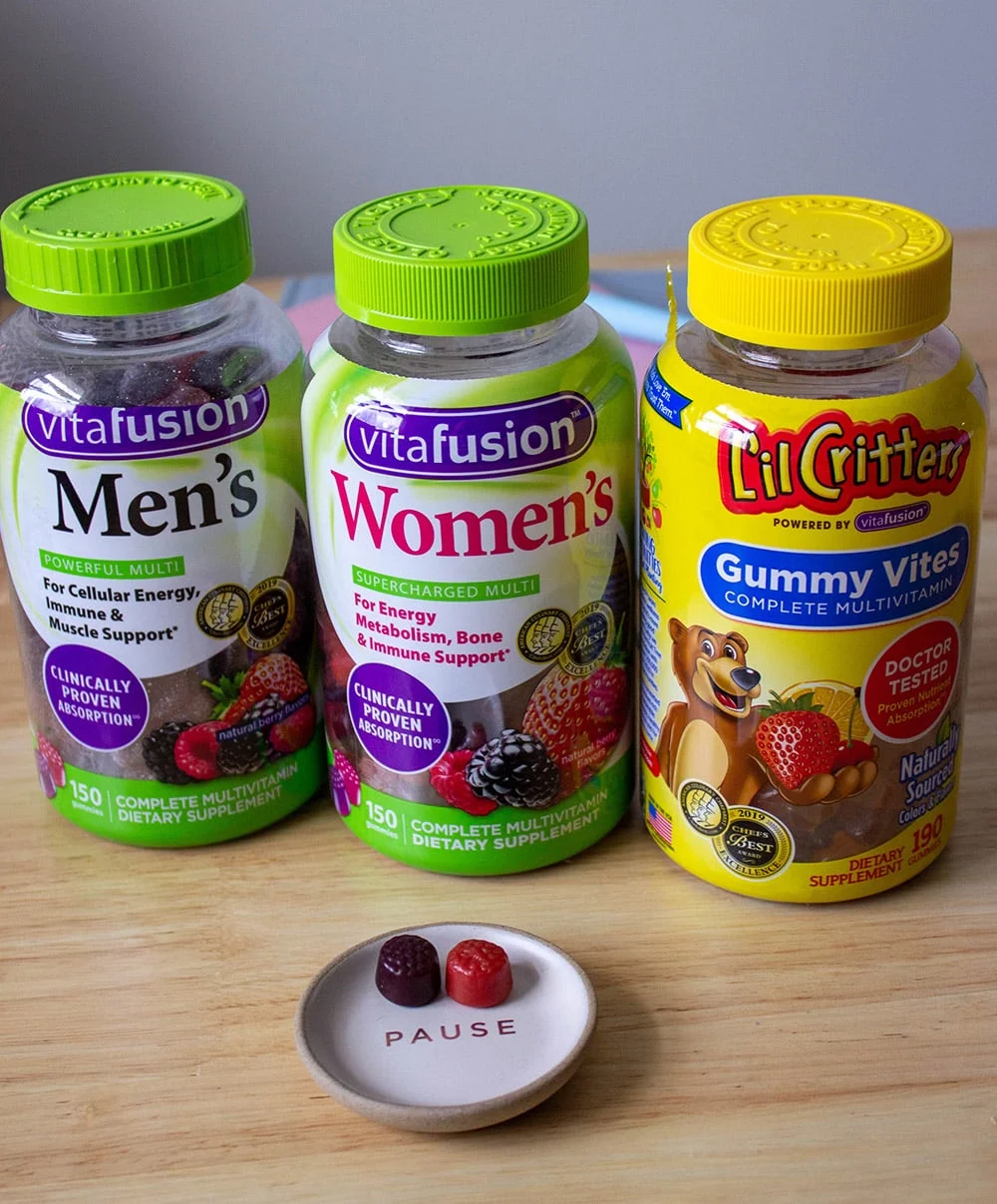 Gummy vitamins in bottles and two on a little dish. 