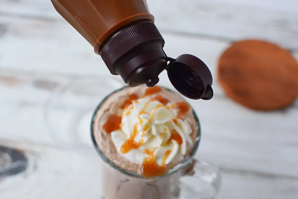 Adding caramel drizzle over whipped cream.