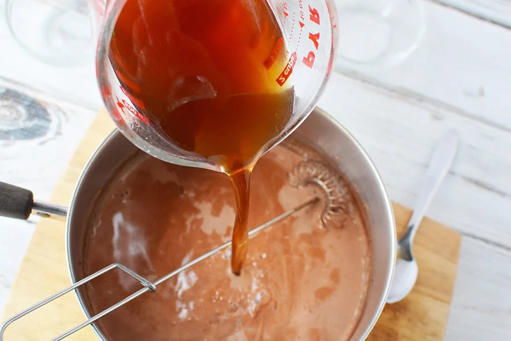 Pouring coffee into hot milk.