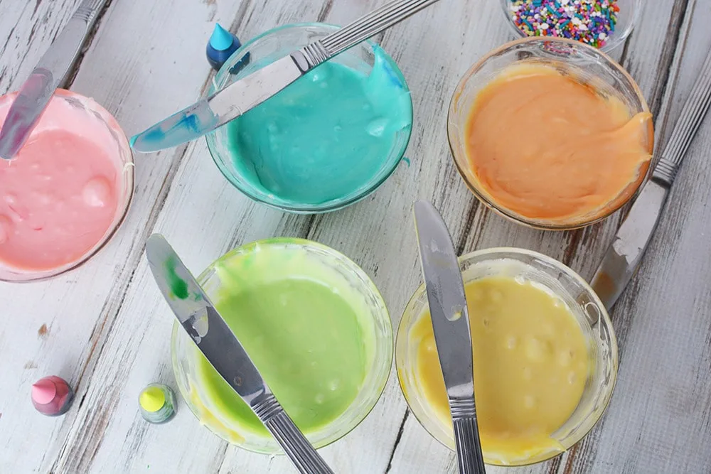 Coloring melted chocolate in rainbow colors in little bowls. 