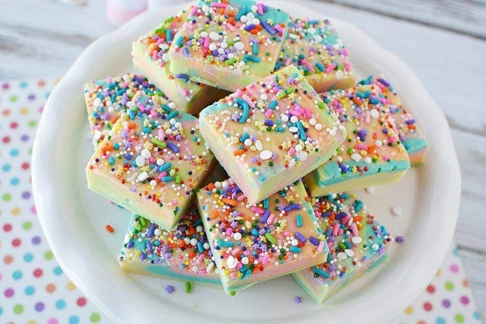 Rainbow unicorn fudge on a plate in slices.