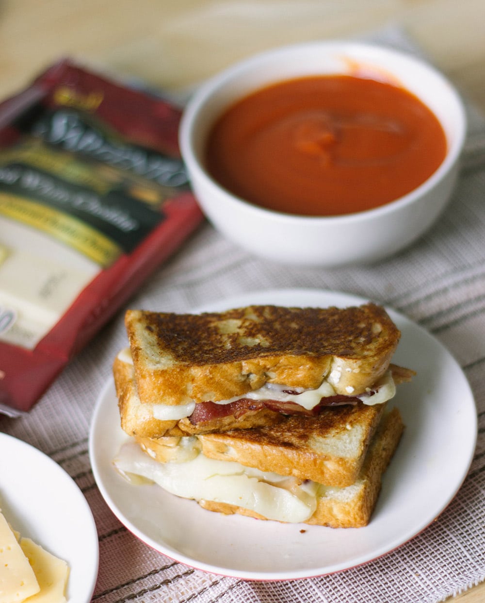 Grilled cheese sandwich on plate by tomato soup