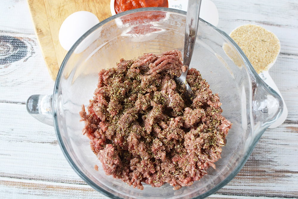 Ground beef and seasonings in a bowl.