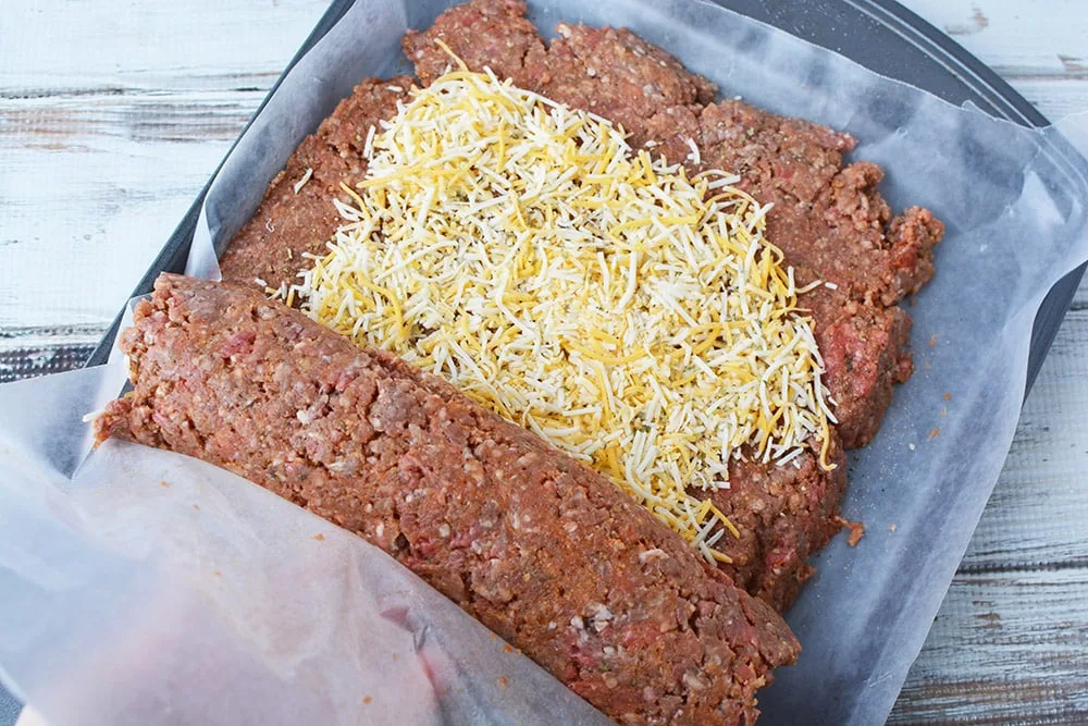 Rolling up cheese stuffed meatloaf.