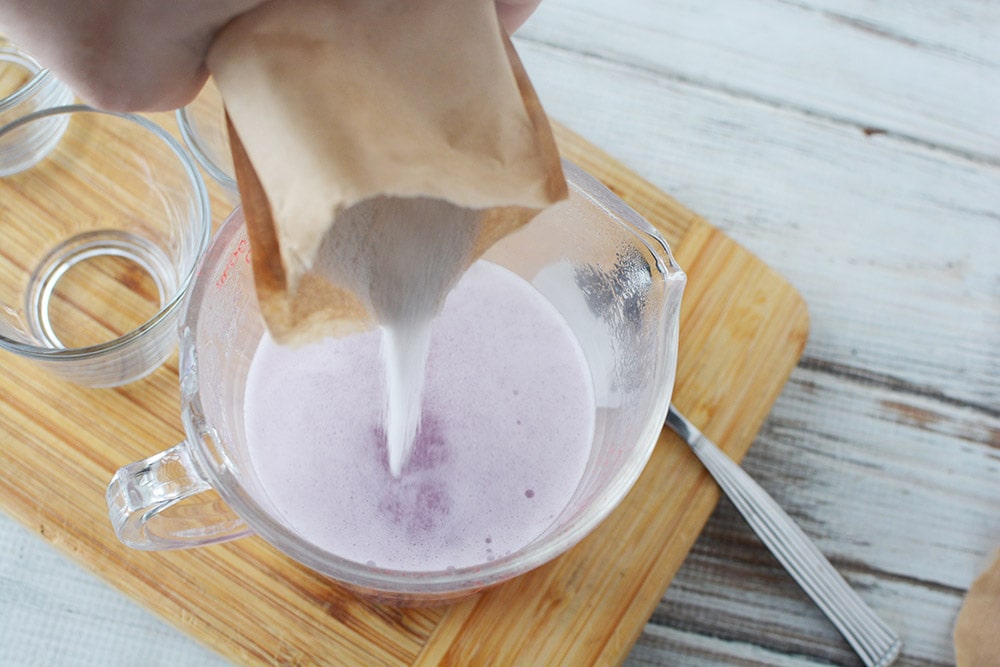 Grape jello powder going into a bowl. 