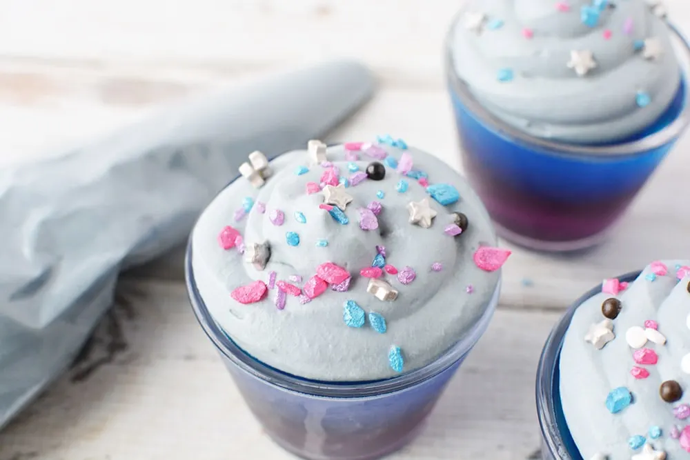 Galaxy sprinkles on top of galaxy jello cups.