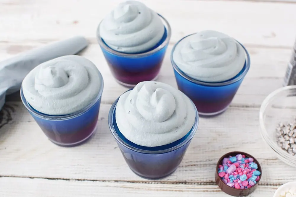 Gray whipped cream on top of jello cups. 