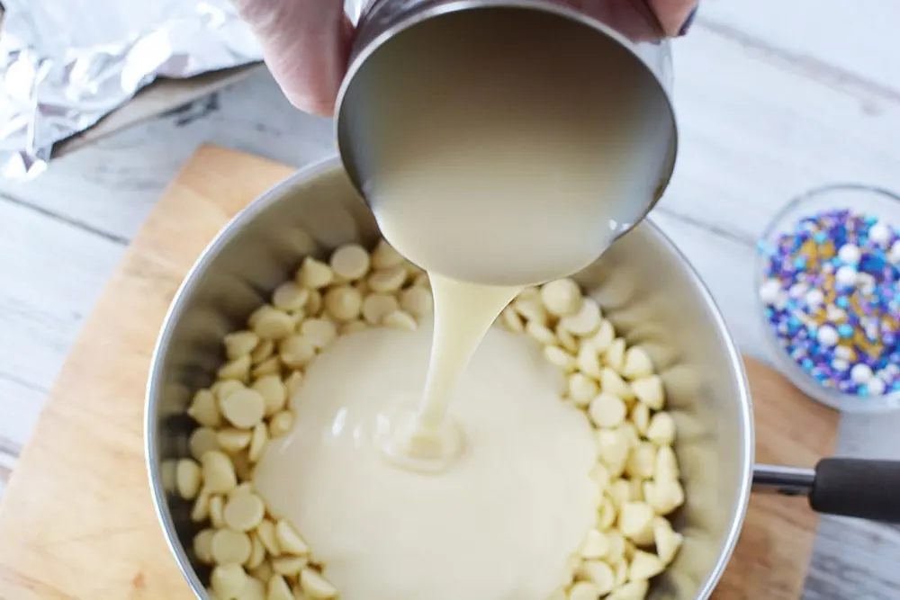 Pouring sweetened condensed milk into chips. 