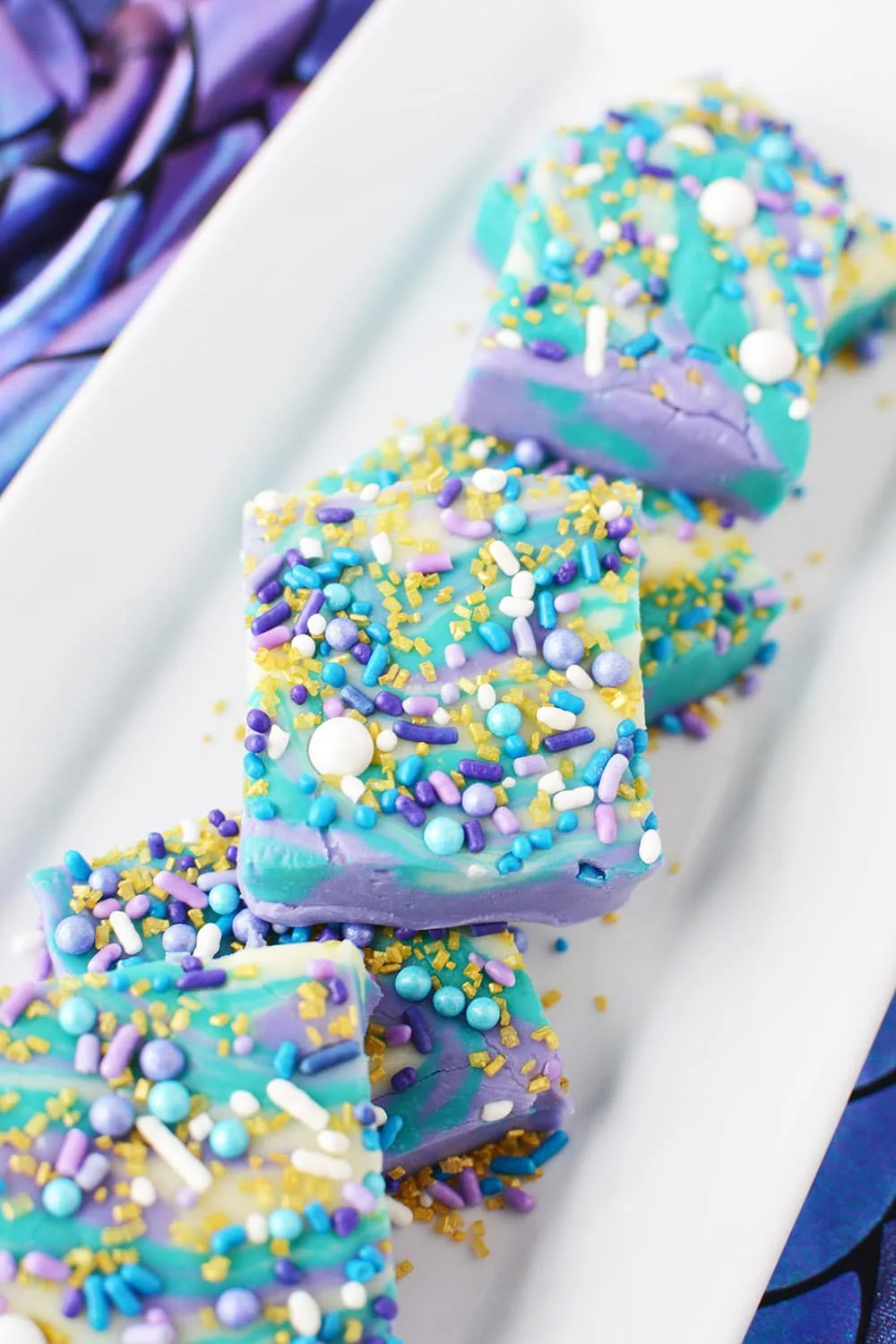 Mermaid candy fudge cut into squares on a plate.