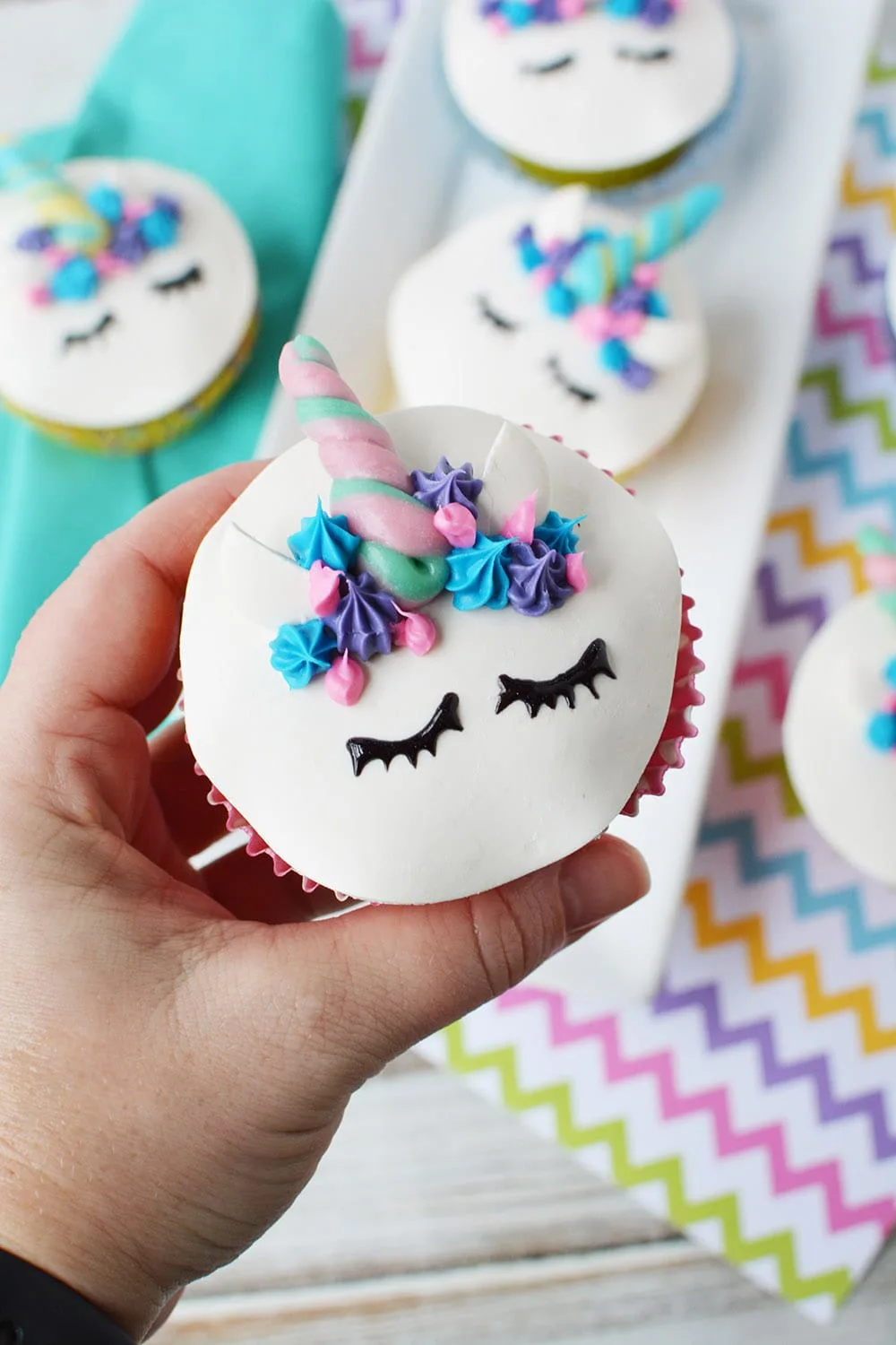 holding a cute unicorn face cupcake