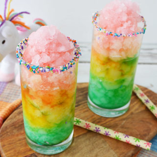 Unicorn slushies in glasses with a stuffed unicorn