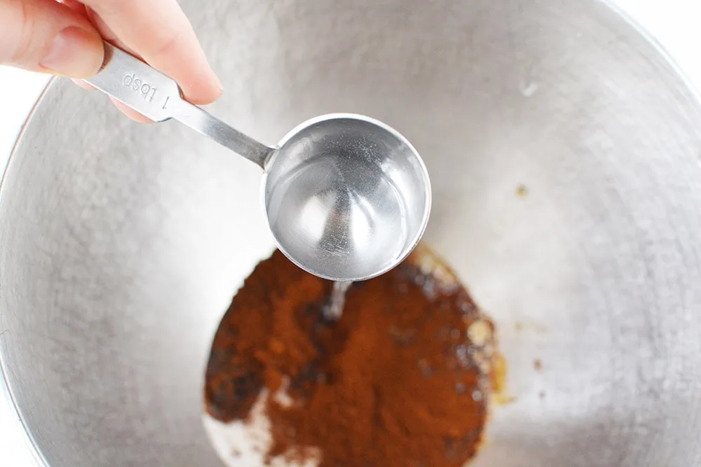 Pouring. water into mixing bowl with whipped coffee ingredients.